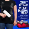 Woman removing white dog fur from a black t-shirt using ChomChom pet hair remover without snagging the fabric.